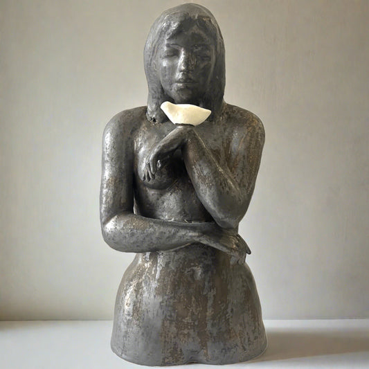 Elegant hand built ceramic sculpture of lady holding a bird. Deep metalic bronze colour  with white bird. Textured finish